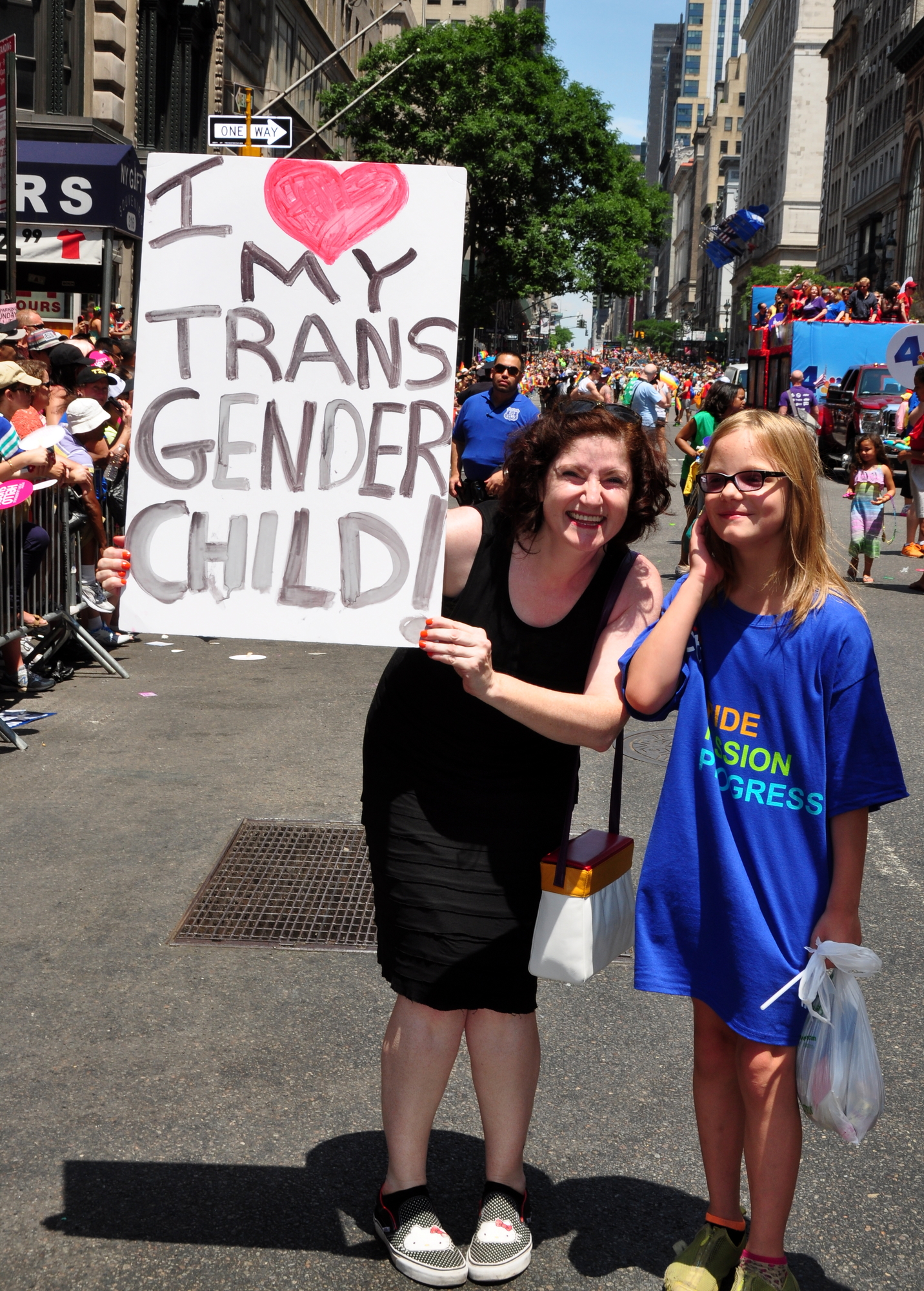 NYC:  Mother holding a sign with her child at the 2014 Gay Pride Parade on Fifth Avenue (stock pic)